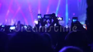 粉丝在节日里拍摄音乐会的照片和视频。